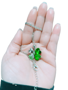 collier trefle vert sur la main d'une femme
